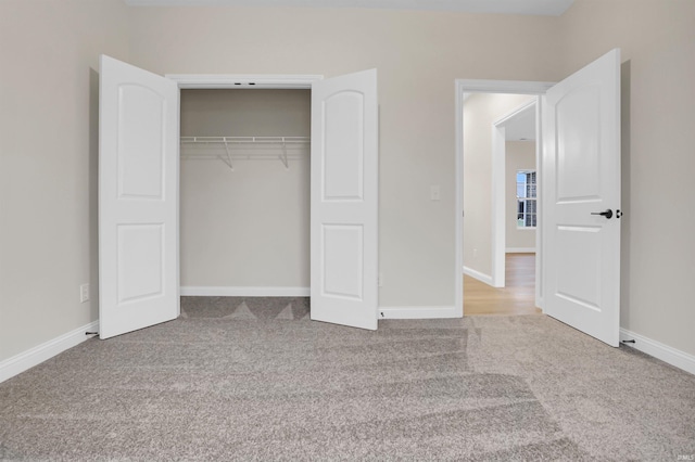 unfurnished bedroom featuring light colored carpet and a closet