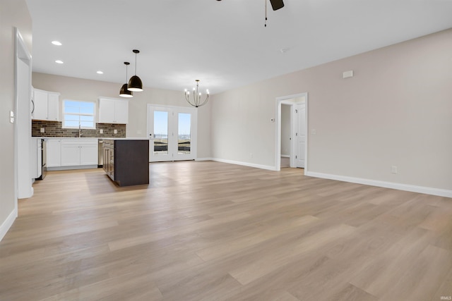 interior space with sink, light hardwood / wood-style flooring, white cabinetry, a center island, and decorative backsplash