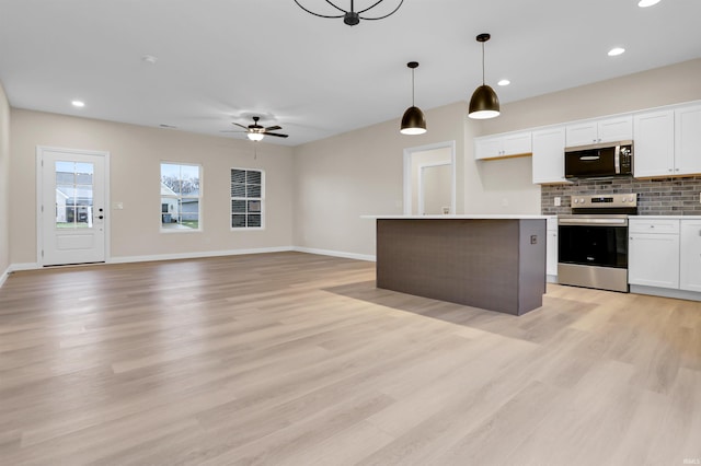 kitchen featuring white cabinetry, appliances with stainless steel finishes, pendant lighting, and backsplash