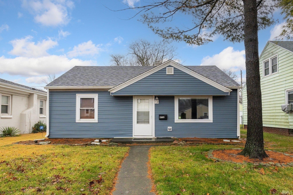 bungalow-style home featuring a front lawn