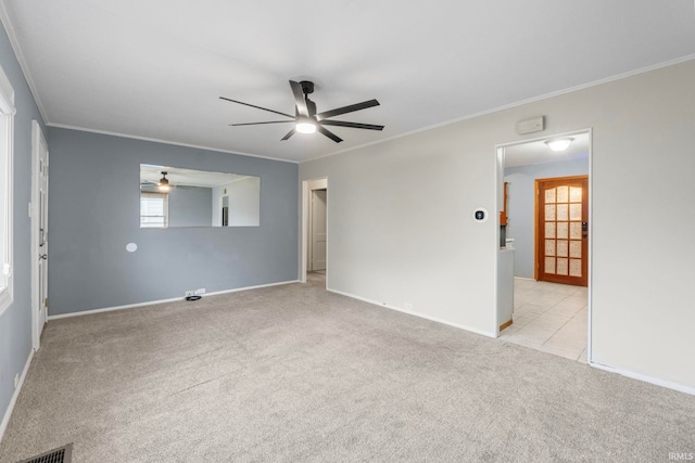 spare room featuring light carpet, crown molding, and plenty of natural light