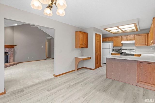 kitchen featuring sink, white refrigerator, range with electric stovetop, a fireplace, and kitchen peninsula