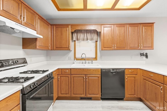 kitchen with sink, light hardwood / wood-style floors, gas stove, and black dishwasher