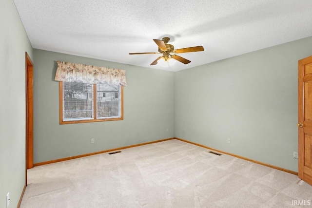 carpeted empty room featuring ceiling fan and a textured ceiling