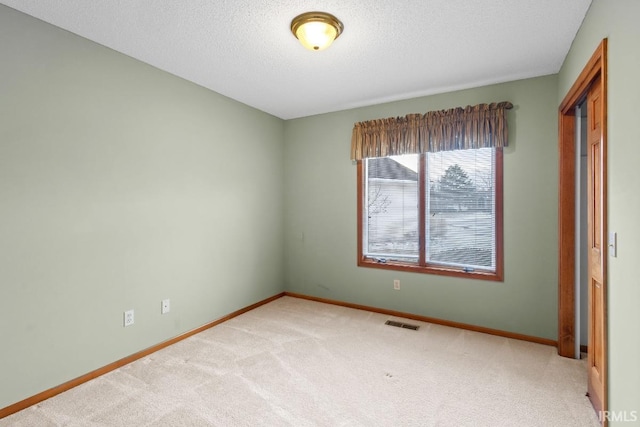 carpeted spare room with a textured ceiling