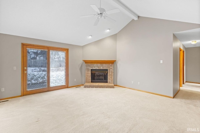 unfurnished living room with ceiling fan, a brick fireplace, light colored carpet, and beam ceiling