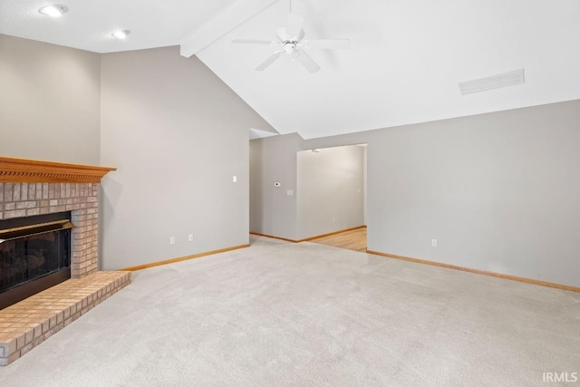 unfurnished living room featuring beamed ceiling, light colored carpet, a fireplace, and ceiling fan