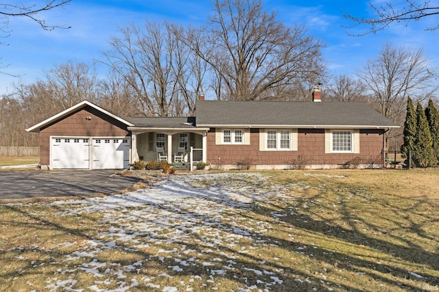 single story home featuring a garage, a yard, and covered porch