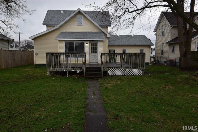 back of house featuring a wooden deck and a yard