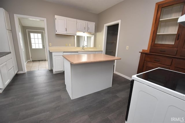 kitchen with white cabinetry, a center island, sink, and white range with electric stovetop