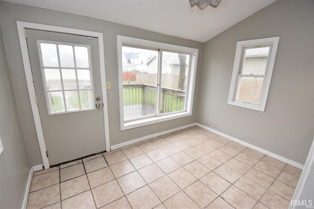 entryway with vaulted ceiling and light tile patterned floors