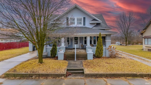 view of front facade with a porch and a yard