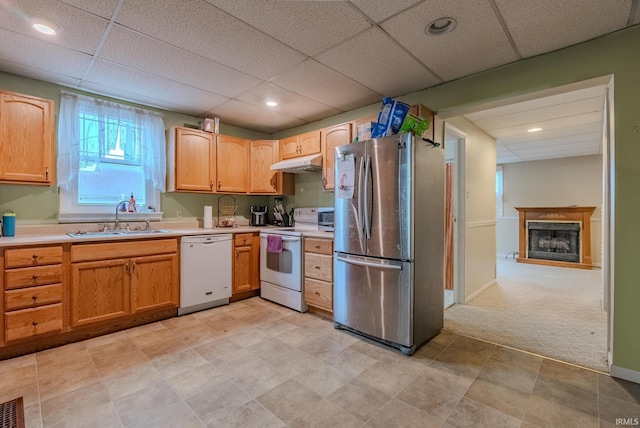 kitchen with a drop ceiling, sink, white appliances, and light colored carpet