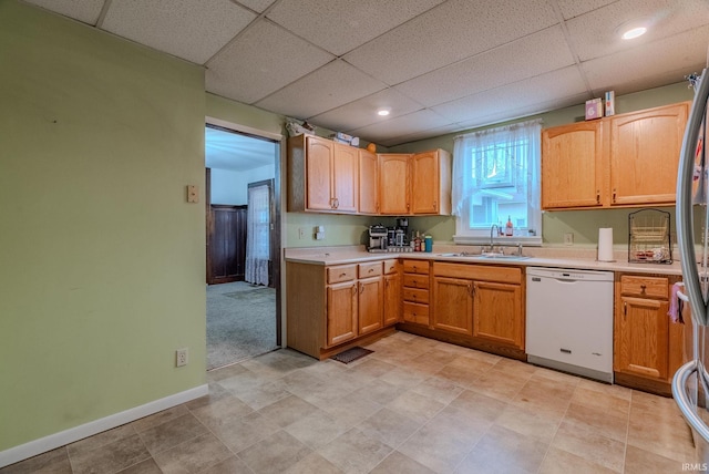 kitchen with white dishwasher, sink, a paneled ceiling, and stainless steel refrigerator