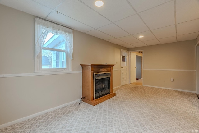 unfurnished living room featuring a drop ceiling and light colored carpet