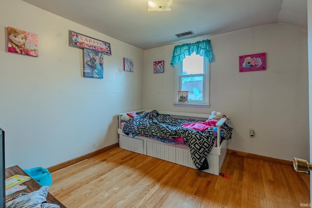 bedroom featuring lofted ceiling and hardwood / wood-style floors