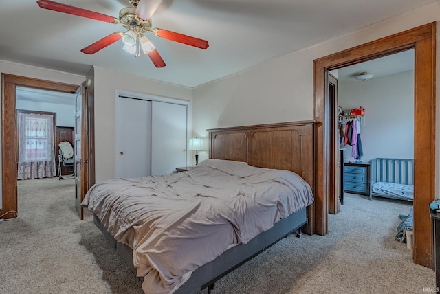 carpeted bedroom featuring ceiling fan and a closet