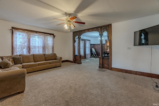 carpeted living room with ceiling fan