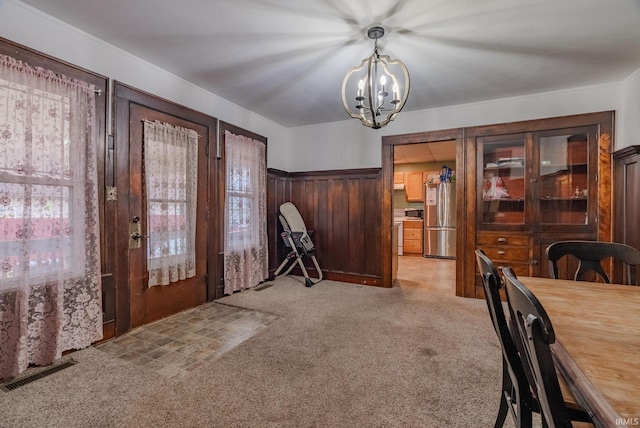 dining room featuring light colored carpet and a chandelier