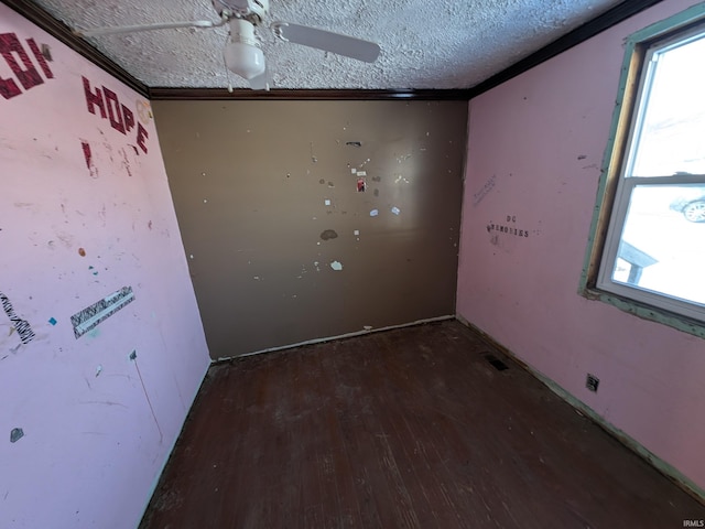 empty room featuring ceiling fan, ornamental molding, dark hardwood / wood-style floors, and a textured ceiling