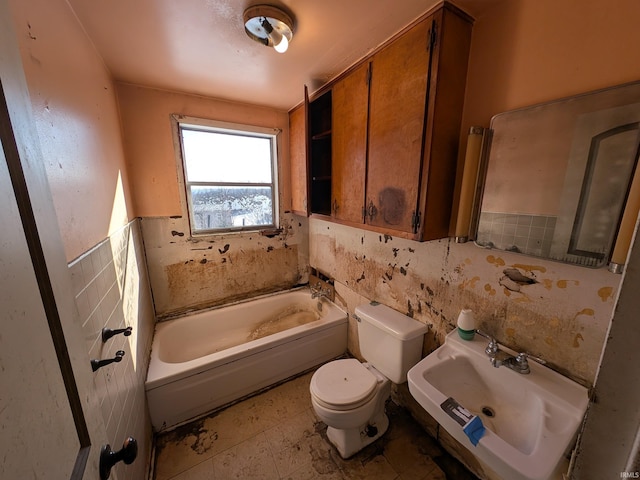 bathroom with tile walls, sink, a bathtub, and toilet