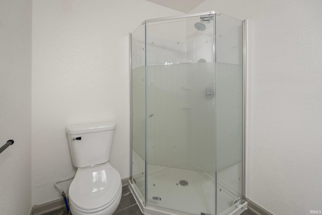 bathroom with a shower with shower door and toilet