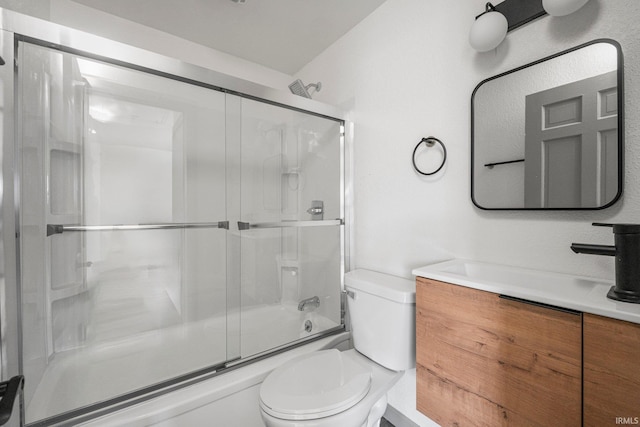 full bathroom featuring vanity, bath / shower combo with glass door, and toilet