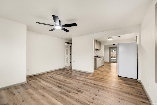 unfurnished living room featuring ceiling fan and light wood-type flooring