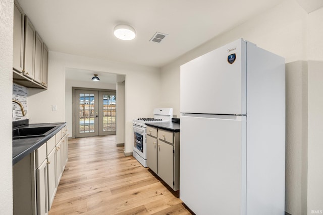 kitchen featuring light wood-type flooring, sink, white appliances, and french doors