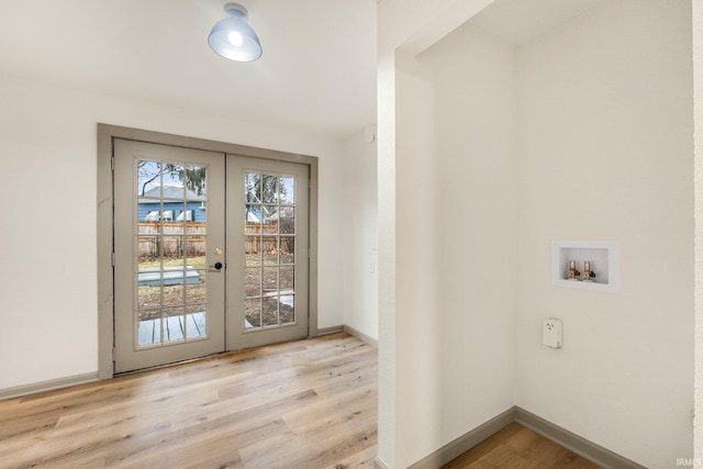 doorway to outside with light hardwood / wood-style flooring, french doors, and a water view