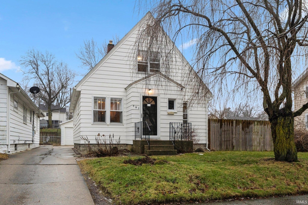 view of front of property featuring an outbuilding, a garage, and a front yard