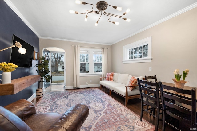 living room with wood-type flooring, ornamental molding, and a chandelier