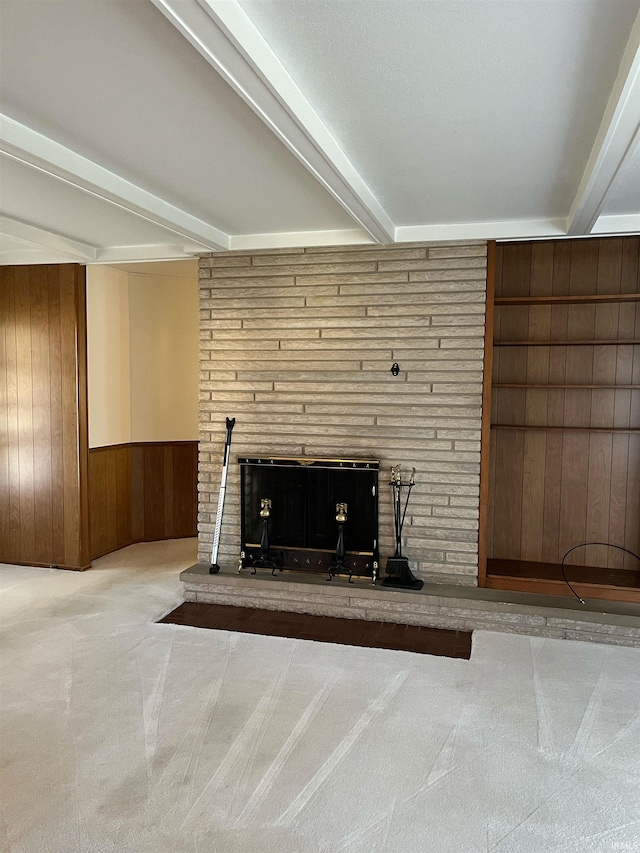 interior details with wooden walls, carpet flooring, beam ceiling, and a fireplace