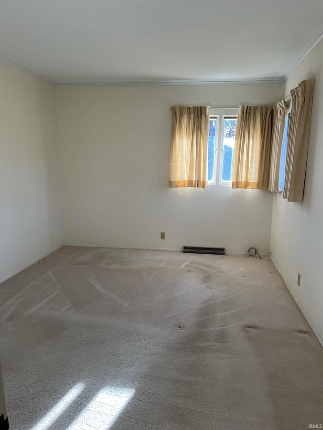 spare room with ornamental molding and light colored carpet