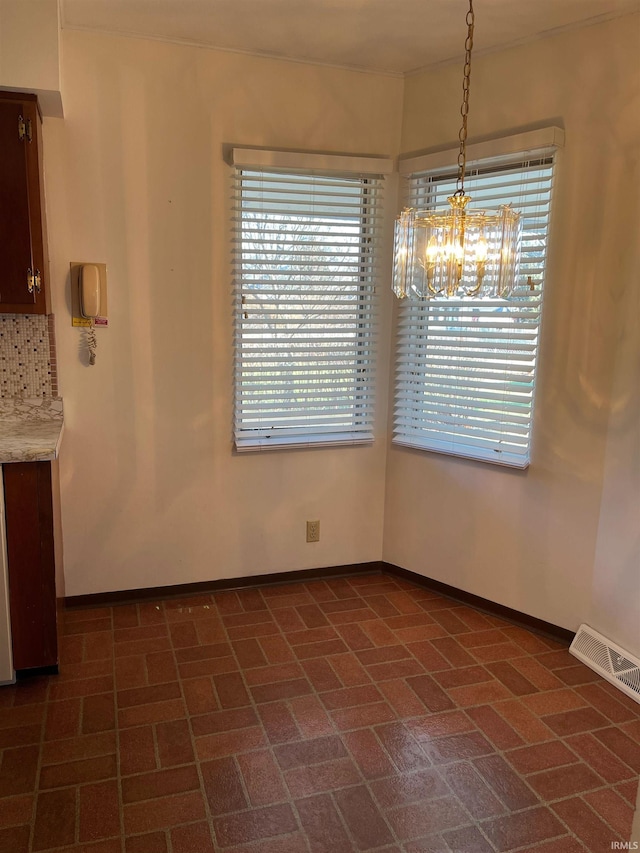 unfurnished dining area with a chandelier