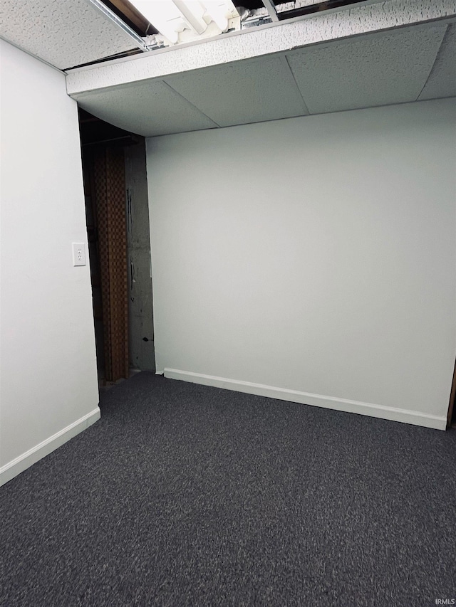 carpeted empty room featuring a paneled ceiling