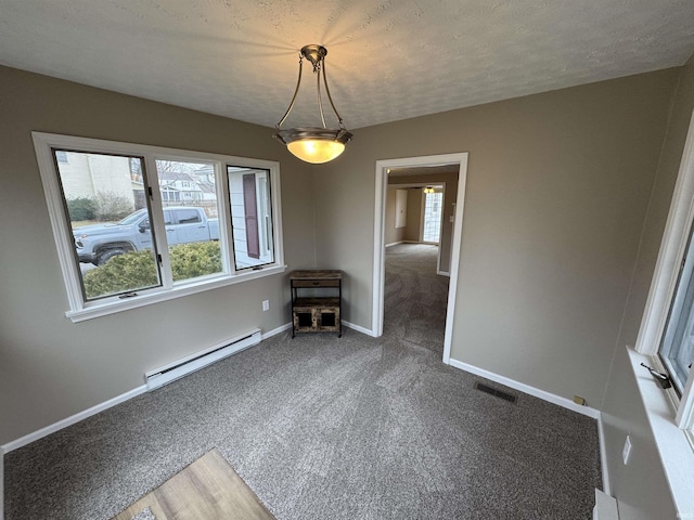 empty room with dark colored carpet, a baseboard radiator, and a textured ceiling