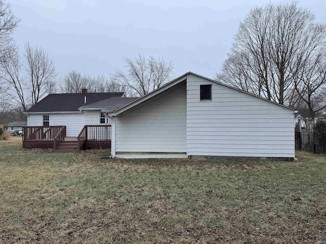 back of property with a wooden deck and a yard