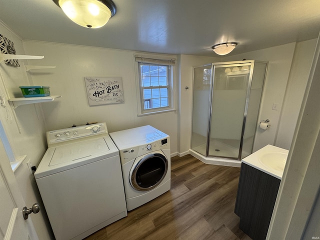 laundry area featuring sink, dark wood-type flooring, and washing machine and clothes dryer