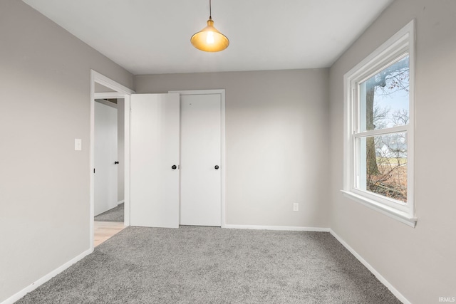 unfurnished bedroom featuring a closet and light carpet