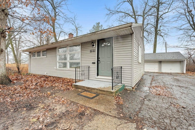 view of front of property with a garage and an outbuilding