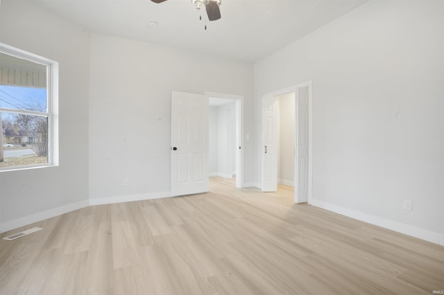 empty room with ceiling fan and light hardwood / wood-style flooring