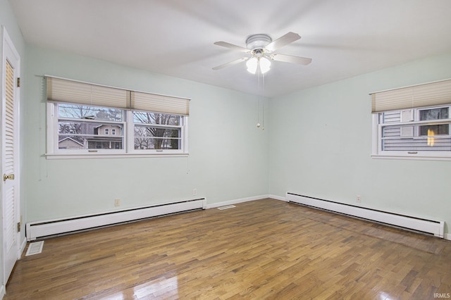 empty room featuring hardwood / wood-style flooring, a baseboard radiator, and ceiling fan