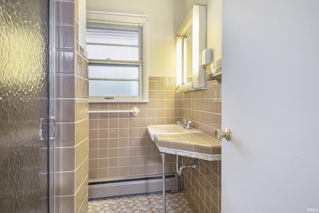 bathroom featuring a baseboard radiator, a shower with shower door, and tile walls