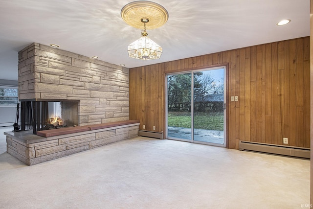 unfurnished living room with wooden walls, a baseboard radiator, and carpet flooring