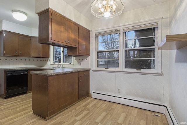 kitchen featuring dishwasher, sink, backsplash, an inviting chandelier, and light hardwood / wood-style flooring