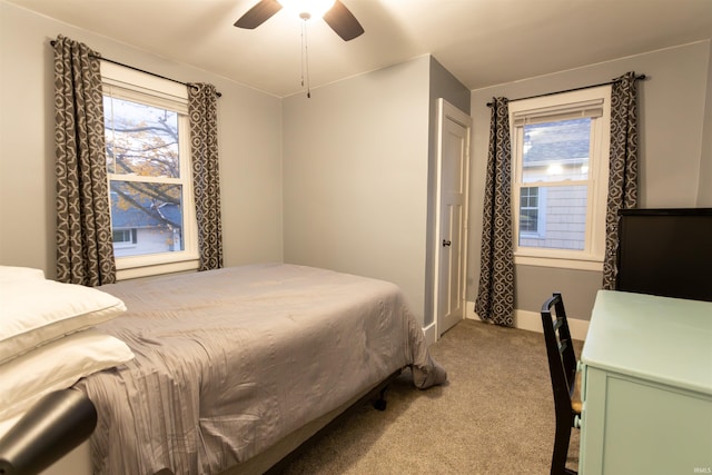 bedroom with multiple windows, light colored carpet, and ceiling fan