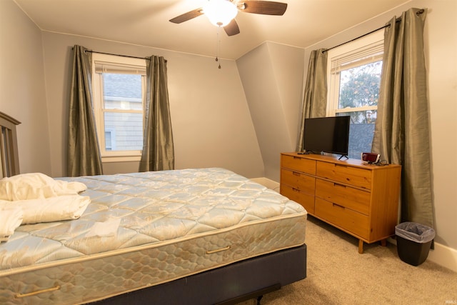 carpeted bedroom featuring multiple windows and ceiling fan