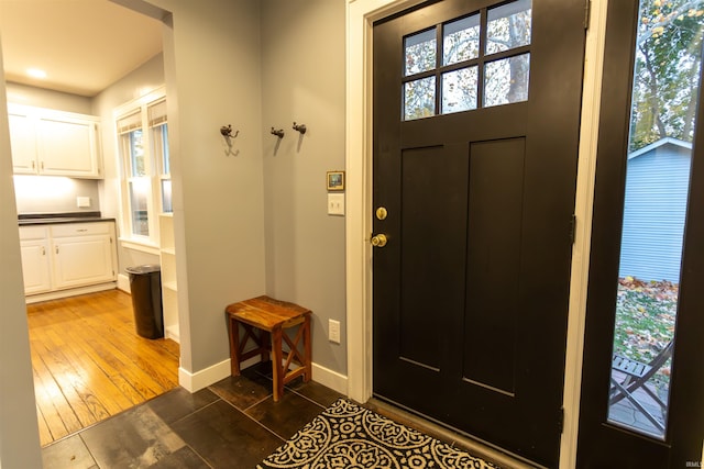 entrance foyer with dark wood-type flooring and a healthy amount of sunlight