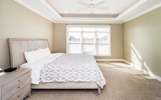 bedroom with crown molding, a tray ceiling, and light carpet